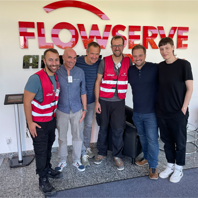 Group of people in front of Flowserve sign